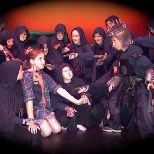 A girl held by snarling Halfmen in black hooded cloaks.