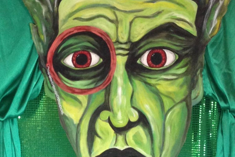 A fierce green face with red eyes