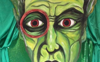 A fierce green face with red eyes