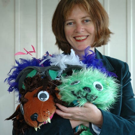 Calico director Jenny Wake carrying the lion and cat costumes from The Wonderful Wizard of Oz
