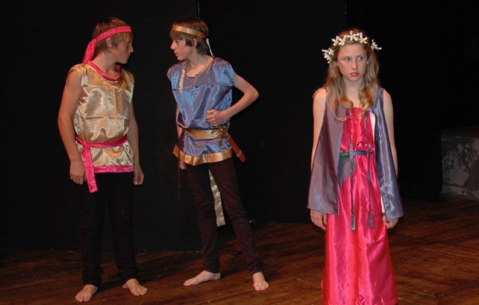 Hermia looking downcast with Lysander and Demtetrius glaring at each other in the background
